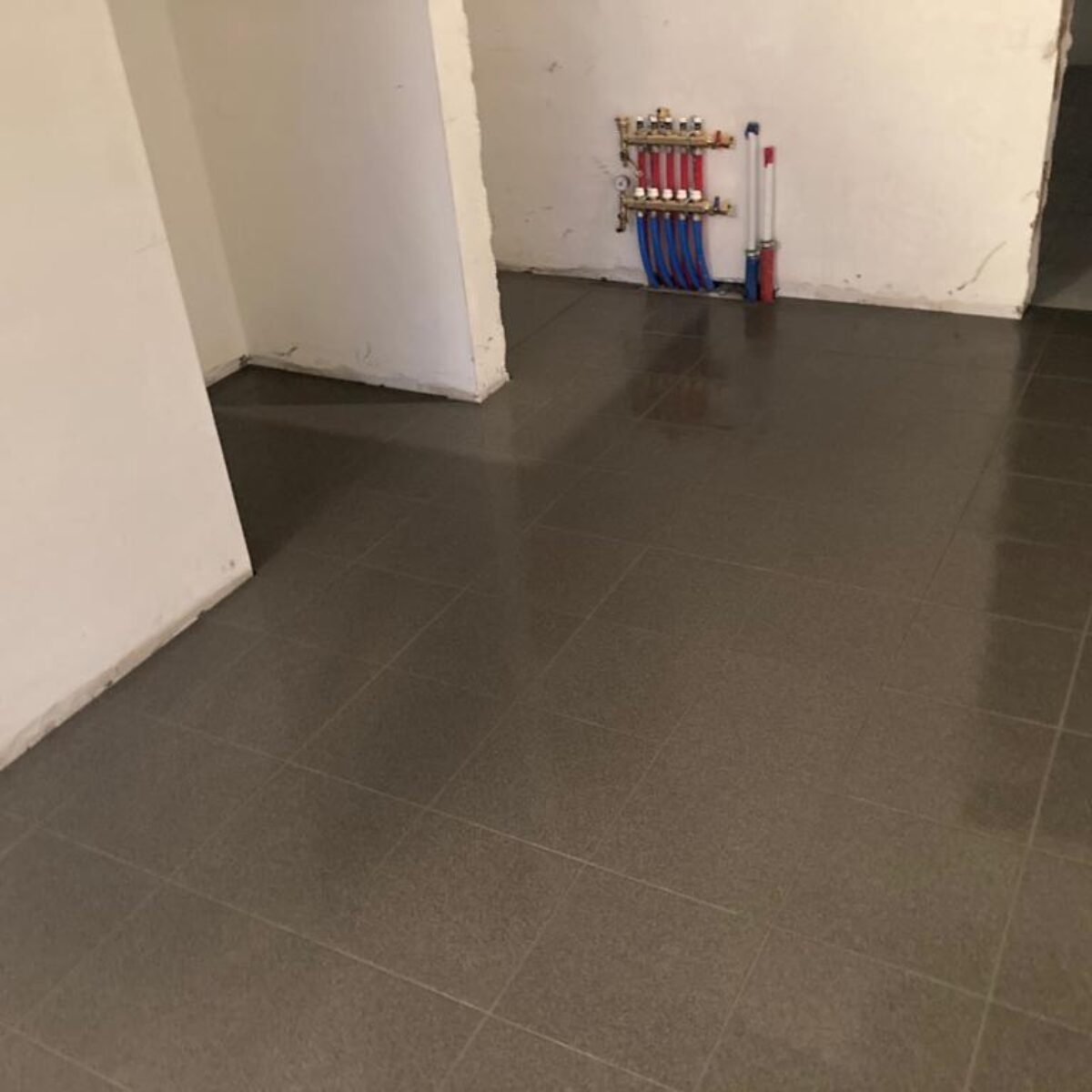 Plaatsen van tegels 30×30 verlijmd in garage te Buggenhout
