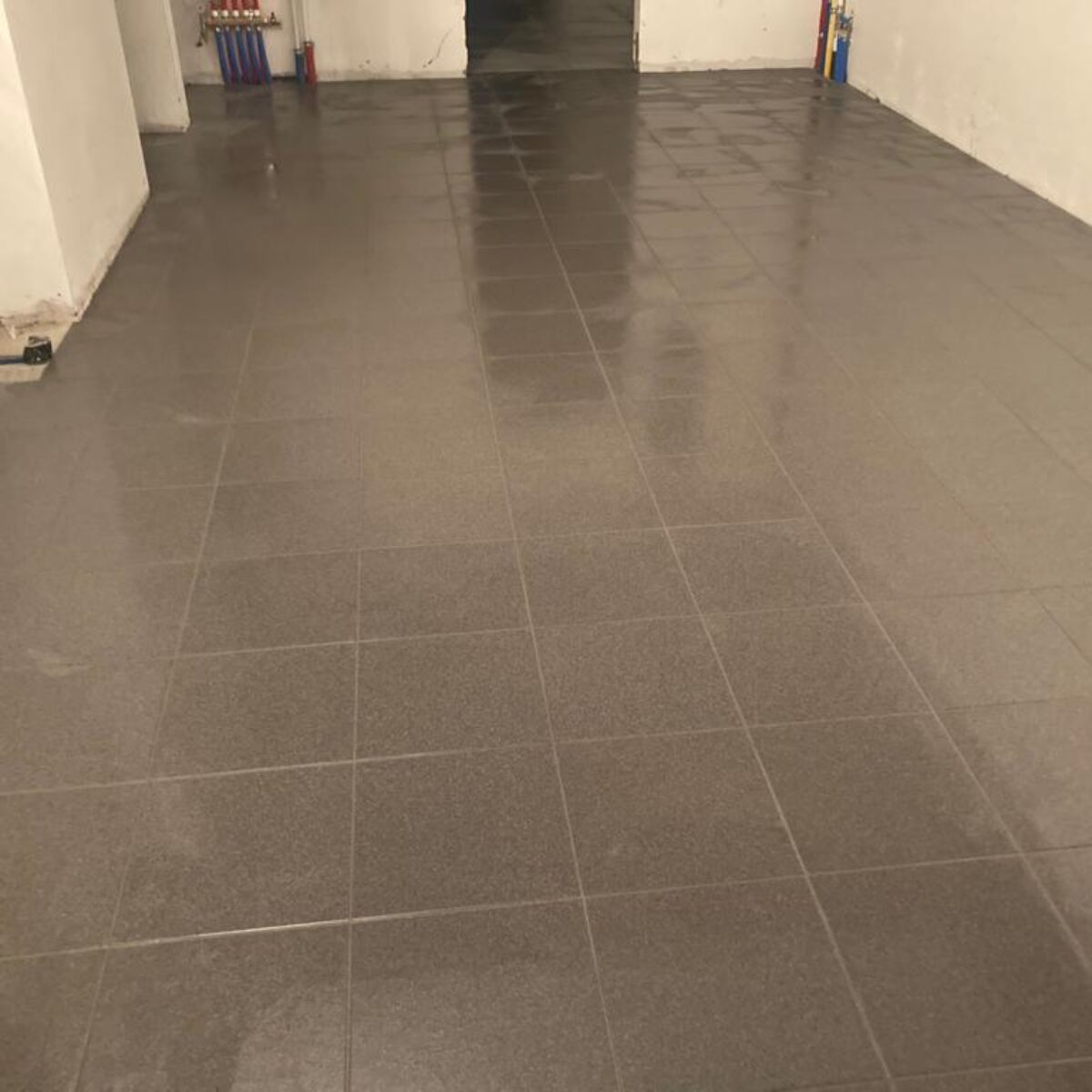 Plaatsen van tegels 30×30 verlijmd in garage te Buggenhout