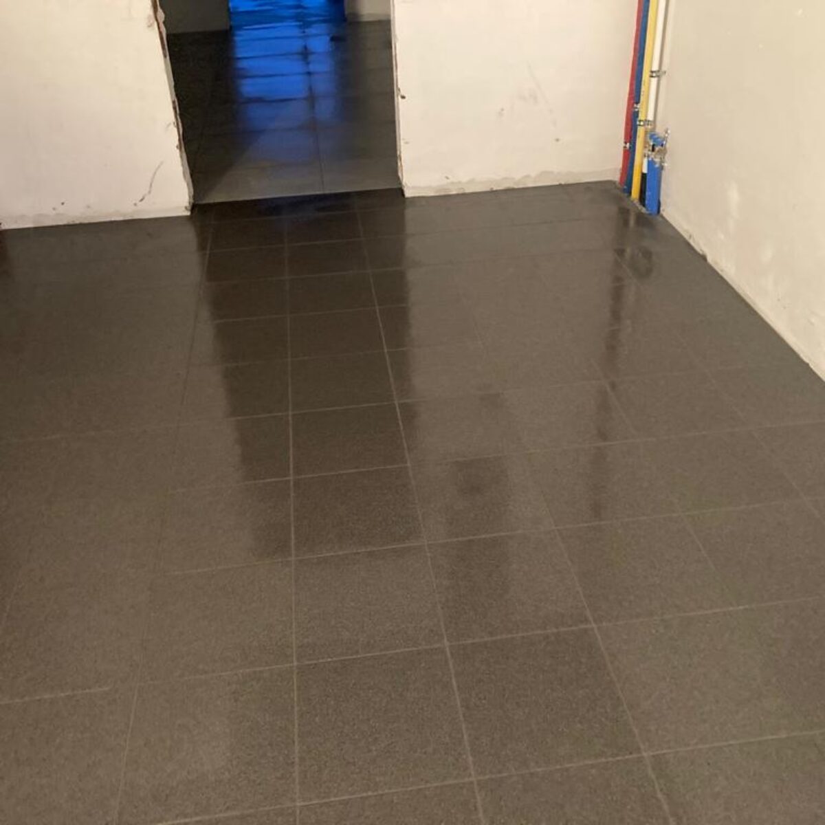 Plaatsen van tegels 30×30 verlijmd in garage te Buggenhout