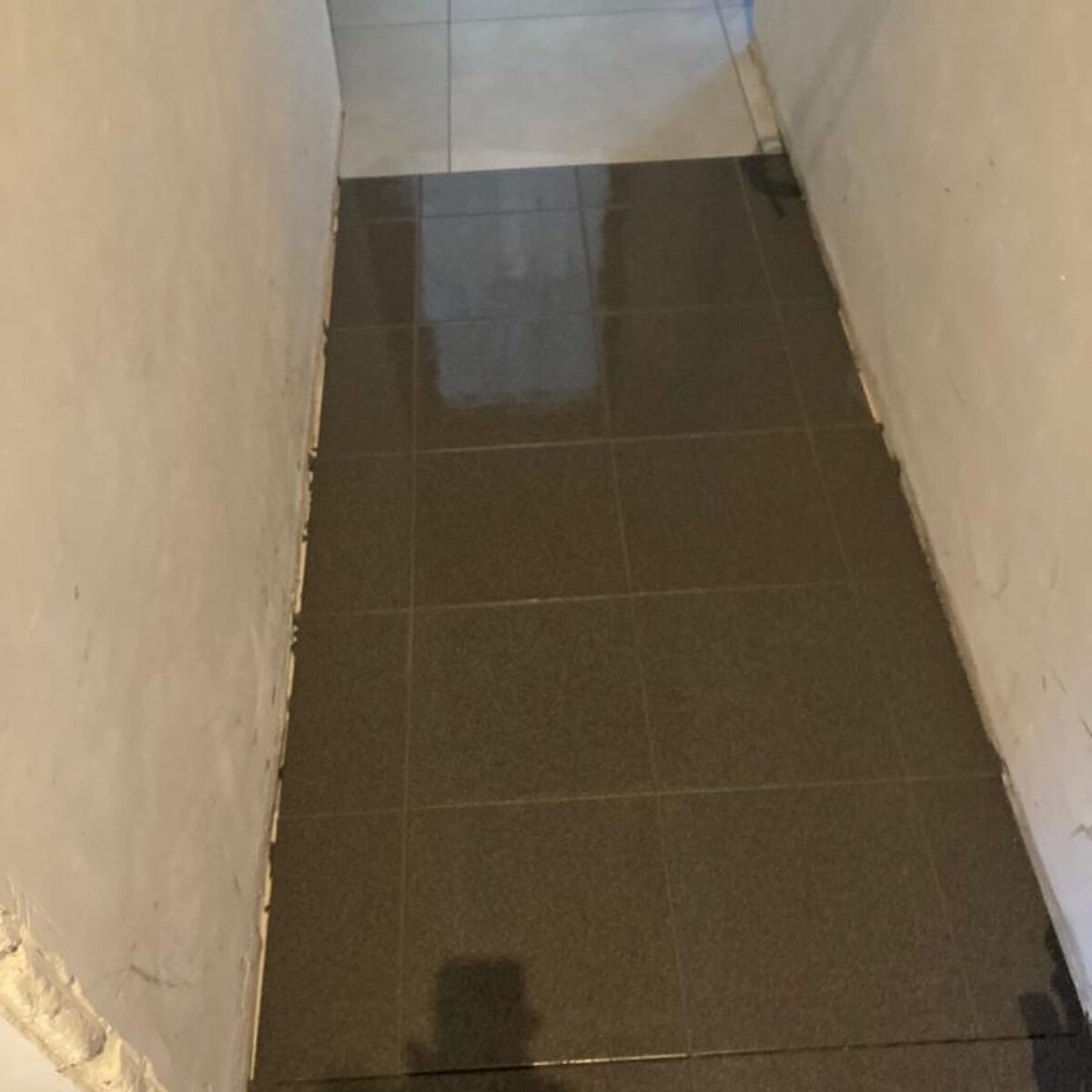 Plaatsen van tegels 30×30 verlijmd in garage te Buggenhout