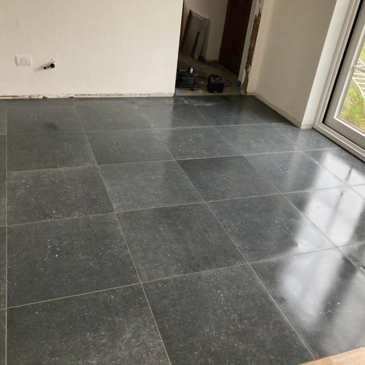 Plaatsen van tegels 60×60 Bleu Stone donker geschuurd in keuken te De Pinte