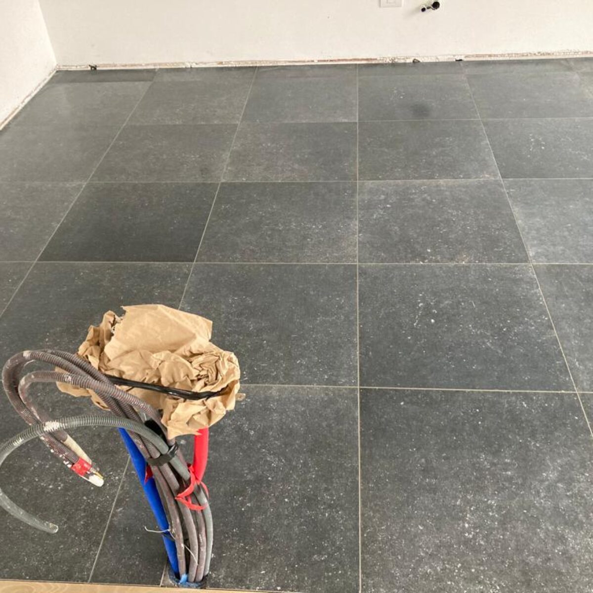 Plaatsen van tegels 60×60 Bleu Stone donker geschuurd in keuken te De Pinte