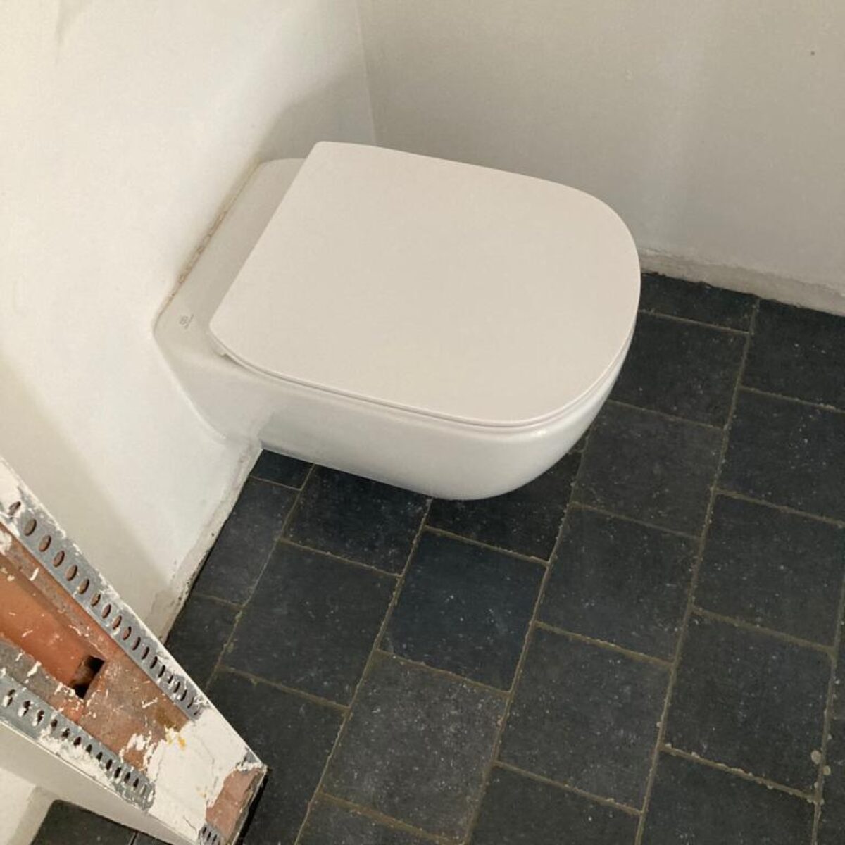 Plaatsen van tegels 20×20 Bleu Stone donker geschuurd – halfsteenverband – hal en wc te De Pinte