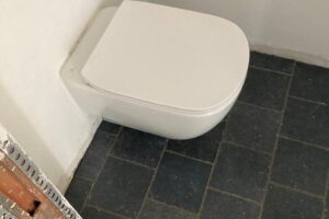 Plaatsen van tegels 20×20 Bleu Stone, donker geschuurd, halfsteenverband – hal en wc te De Pinte