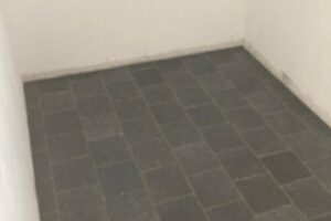 Plaatsen van tegels 20×20 Bleu Stone, donker geschuurd, halfsteenverband – hal en wc te De Pinte