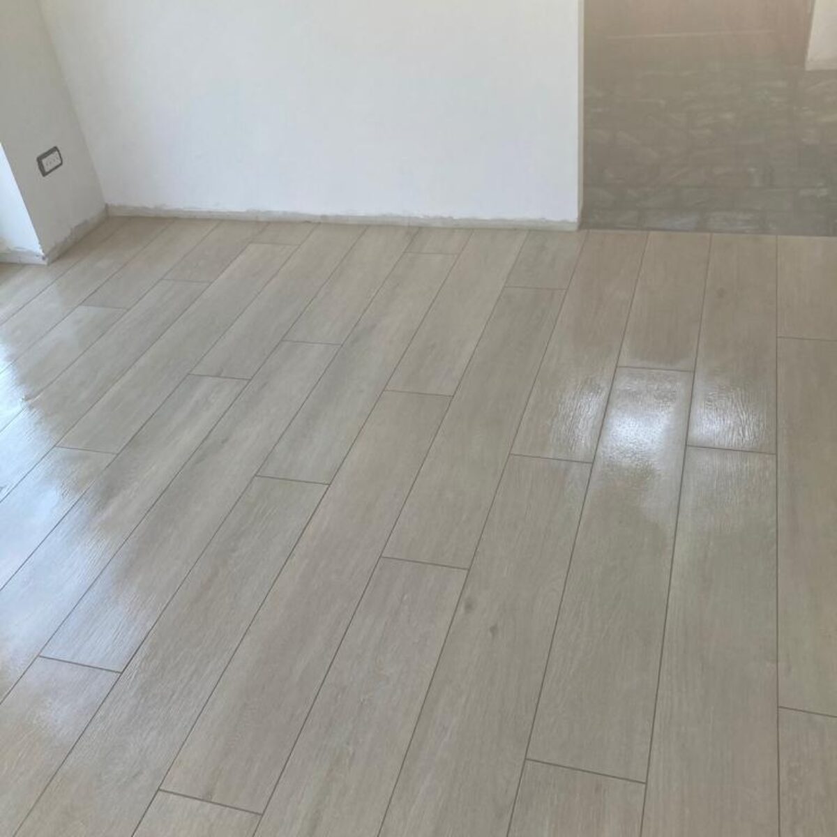 Plaatsen van parket-look tegels Viggo Arce Beige 20×120 in living en bureel te De Pinte