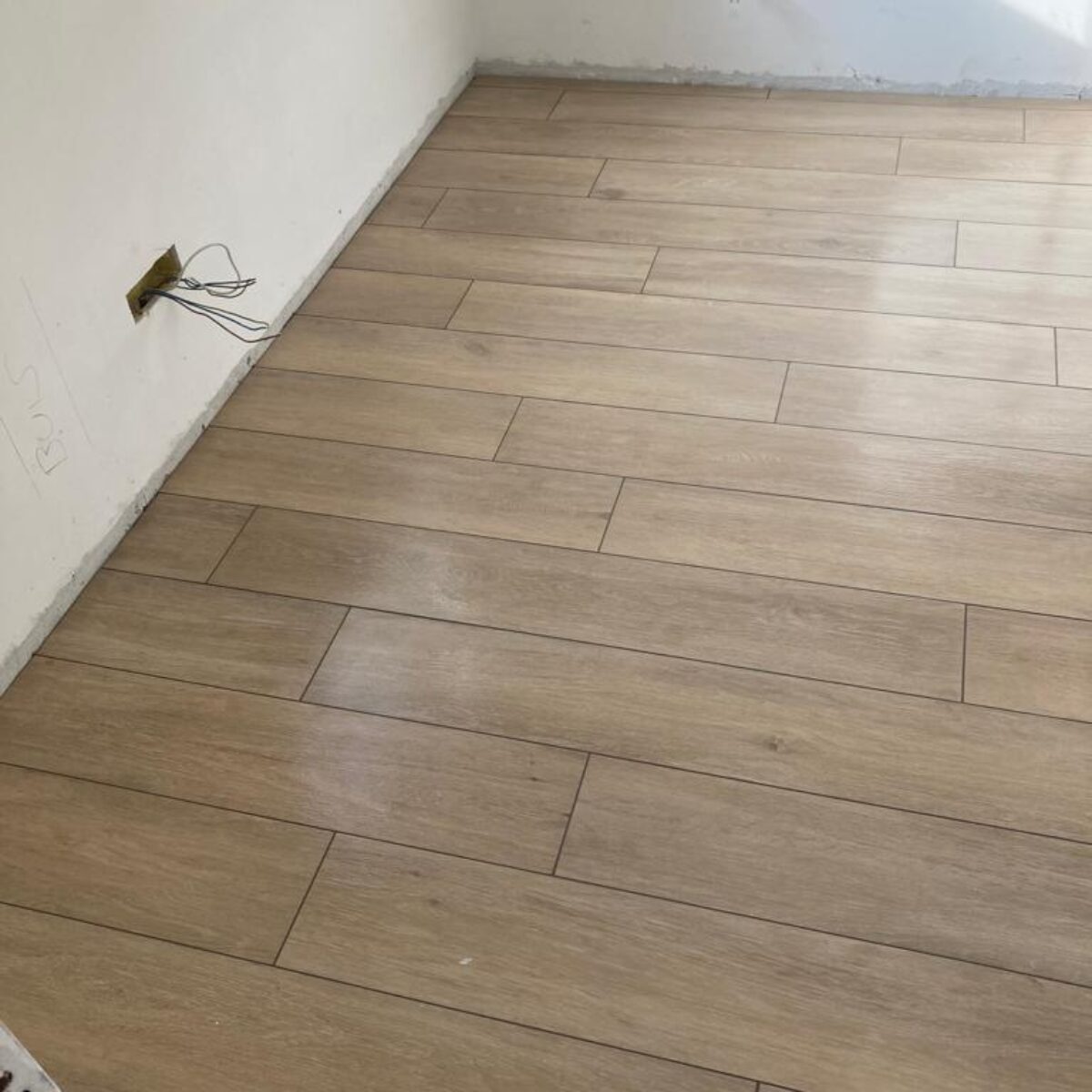 Plaatsen van parket-look tegels Viggo Arce Beige 20×120 in living en bureel te De Pinte