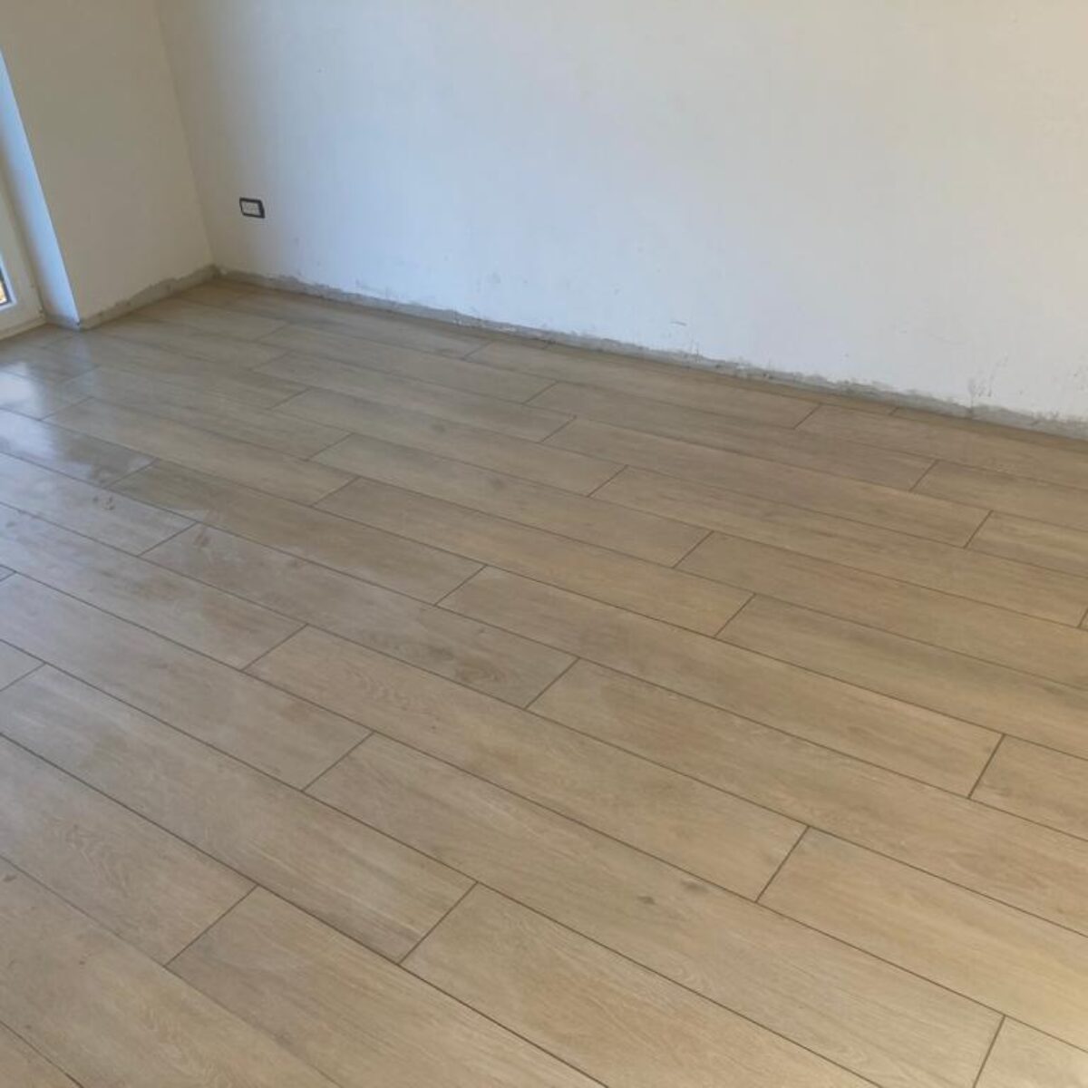 Plaatsen van parket-look tegels Viggo Arce Beige 20×120 in living en bureel te De Pinte